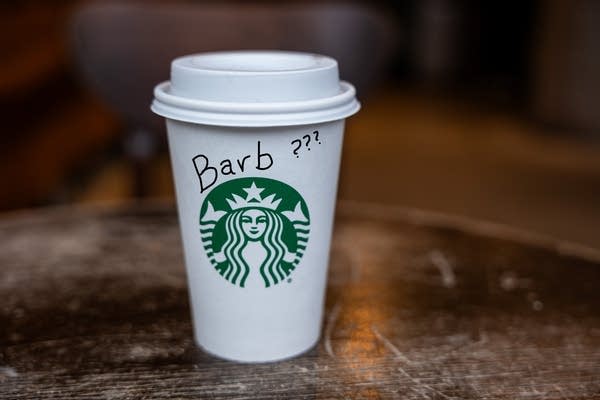 A Starbucks takeaway cup rests on a table