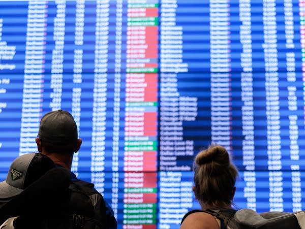 ORLANDO, FLORIDA - NOVEMBER 09: Passengers look at flight delays on a departure board at Orlando International Airport (MCO) on November 09, 2025 in Orlando, Florida. The FAA (Federal Aviation Administration) announced that it will reduce flights by 10 percent at 40 major airports nationwide, amid air traffic control staffing shortages resulting from the federal government shutdown. (Photo by Andrew Wevers/Getty Images)
