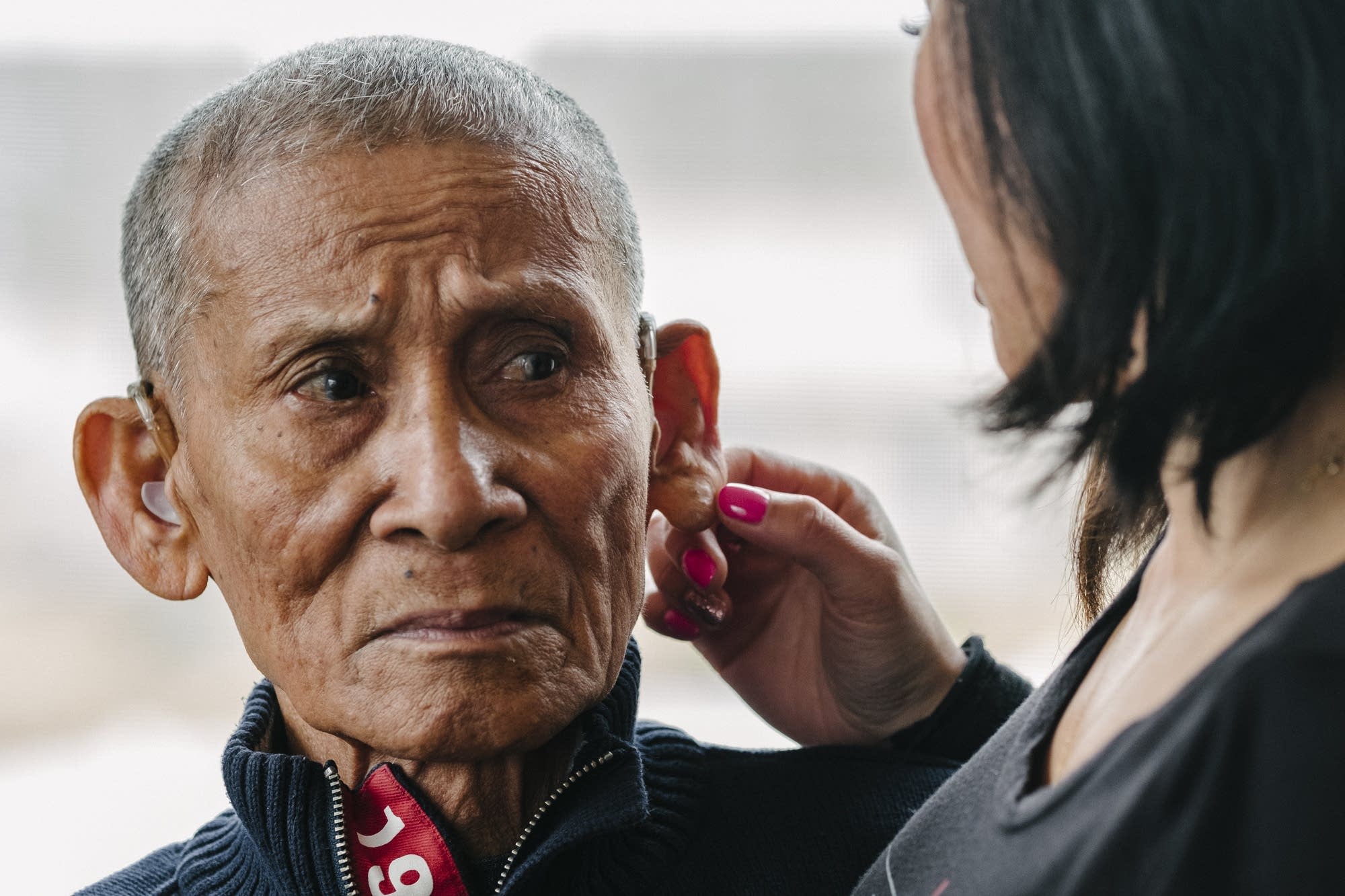 Montha Chum rubs her father Phan Khiev's ear.
