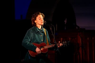 Woman playing guitar on stage