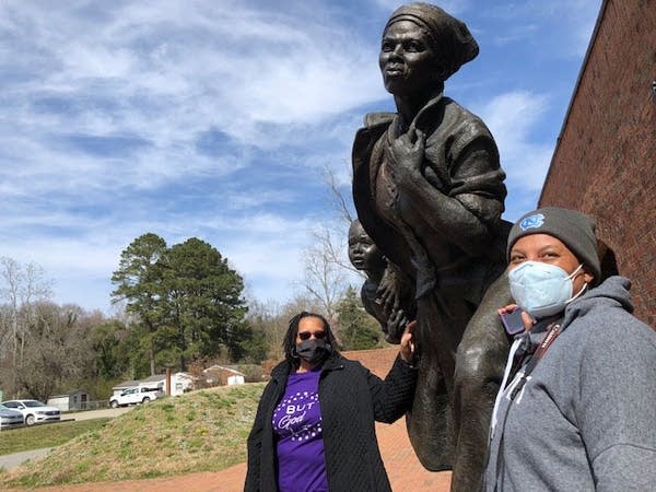 Vanessa Harrell (left) and Sharon Harrell (right) are shown with a traveling statue of Harriet Tubman.