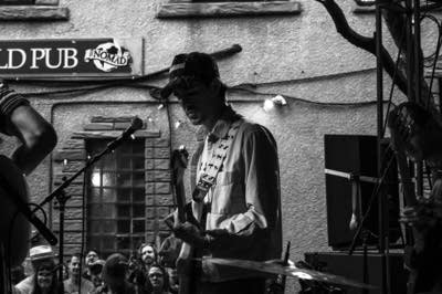 A rock band performing on an outdoor stage