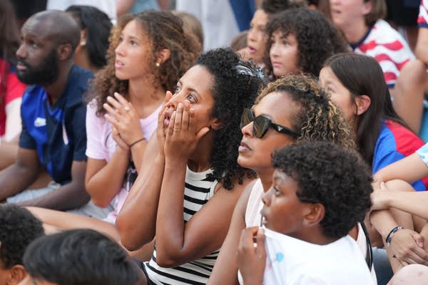People watch a soccer came nervously