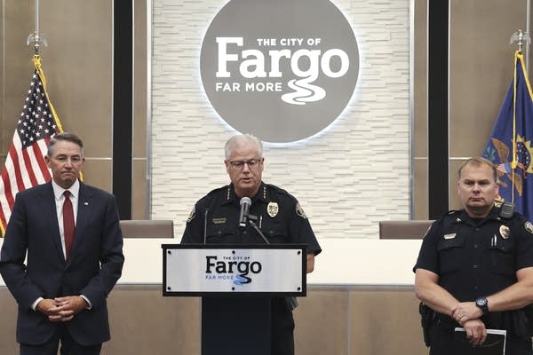 A man speaks behind a podium.