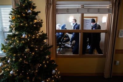 A person is pushed on a stretcher past a Christmas Tree.