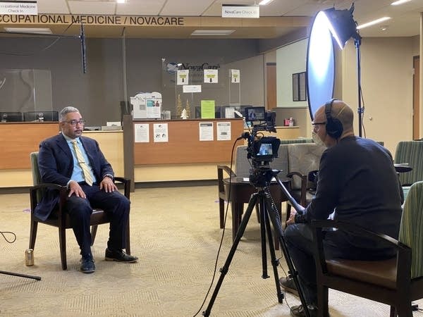 A man sits while being interviewed on camera.