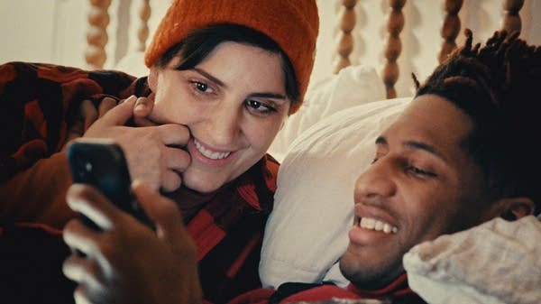 Two people look at a smartphone together