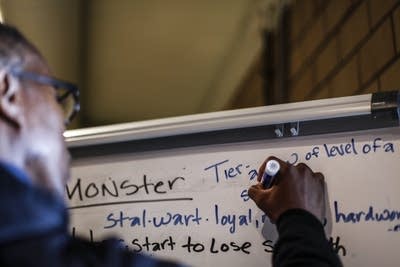 Morgan McDonald Sr. writes terms on a whiteboard.