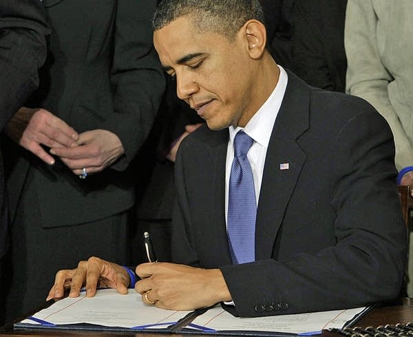 Obama signs historic health care bill into law