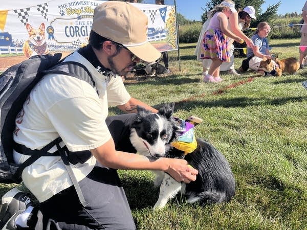 A man and his dog embrace after a race.