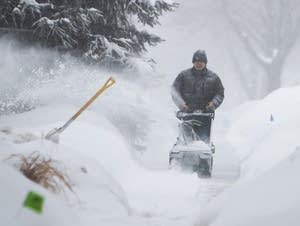 Harry Huie clears snow from the sidewalk in front of his house.