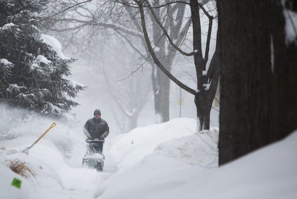 Harry Huie clears snow from the sidewalk in front of his house. 