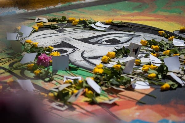 Flowers lie on top of a mural