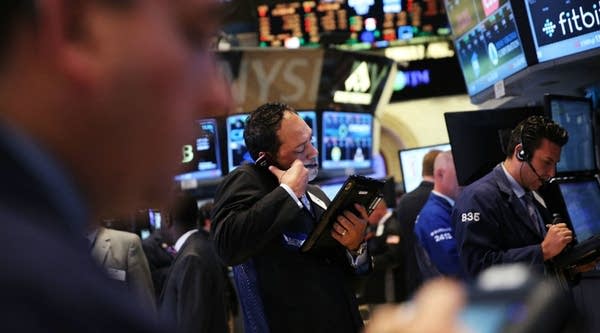 Traders work on the floor of the New York Stock Exchange. When one exchange is down, stocks can be bought and sold on another. 