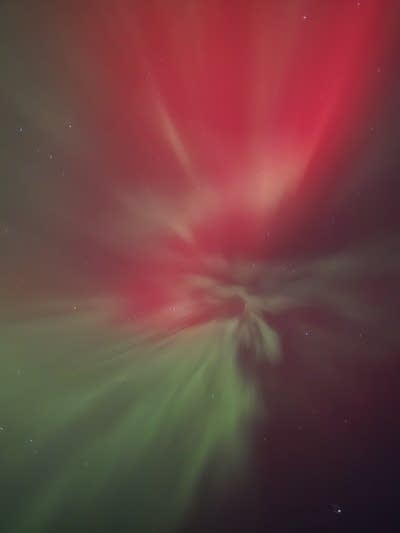 Reds and greens cover the night sky.