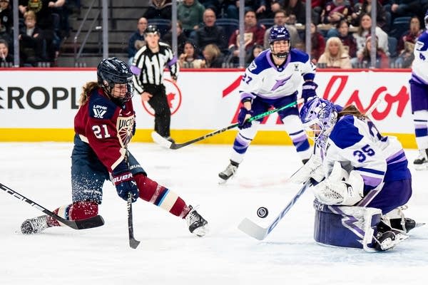 A Montreal hockey player shoots the puck toward the Frost goalie.