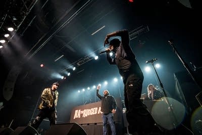 A rapper performs onstage during a show in a music venue