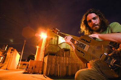 A man holding a resonator guitar