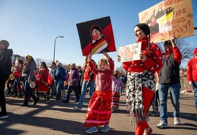 Two people hold signs