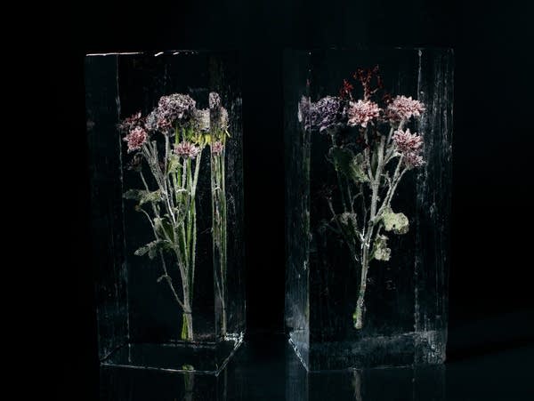 Two small flower bouquets encased in clear ice