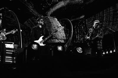 Three musicians performing onstage