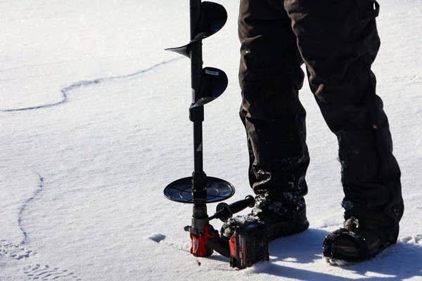 person using an auger
