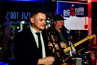 Two musicians perform together onstage