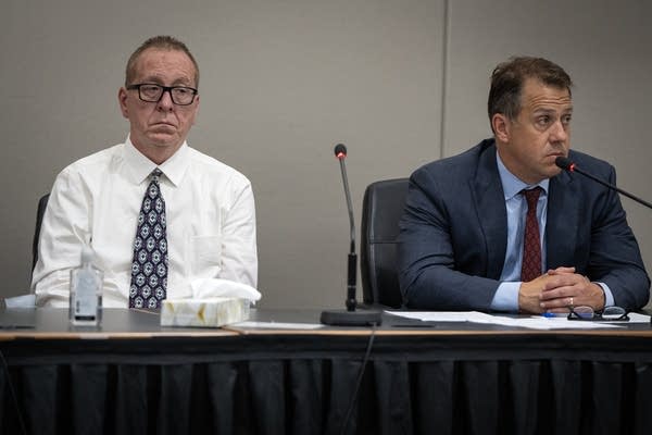 Two men sit at a table