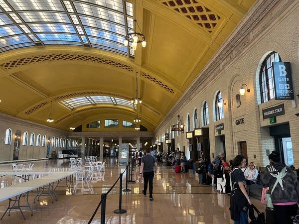 A view of the concourse with people lining up near the wall.