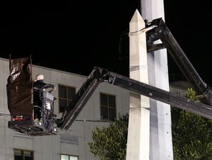 Workers dismantle the Liberty Place monument