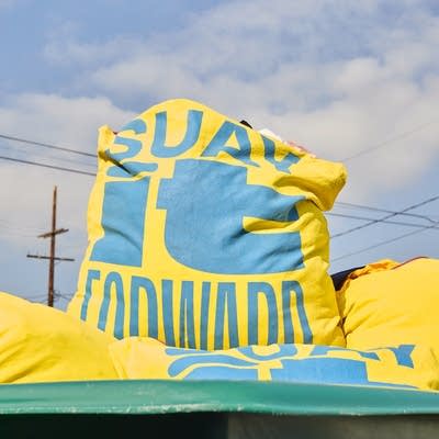 a bag filled with textiles labeled SUAY it forward