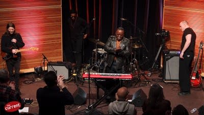 An audience applaud and cheer a band who have completed a performance
