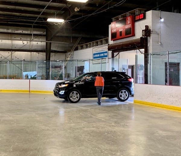 A car pulls into an ice rink. 