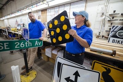 Two people posing with street signs