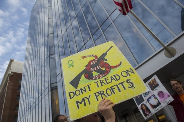 WASHINGTON, DC - APRIL 2, 2014:  A woman holds a sign during a gun control rally outside the National Shooting Sports Foundation's annual Congressional Fly-In fundraising dinner April 2, 2014, in Washington, DC. Demonstrators protested against what they call the corporate gun lobby's obstruction of sensible gun laws such as expanded background checks.  (Photo by Rod Lamkey/Getty Images)