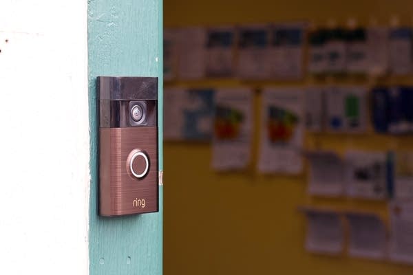 A Ring doorbell is mounted on a light blue wall.