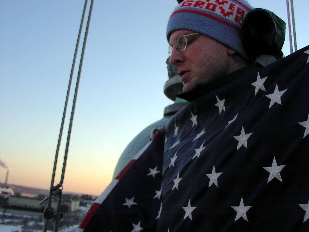 Mark Duclos folds the state capitol American flag.
