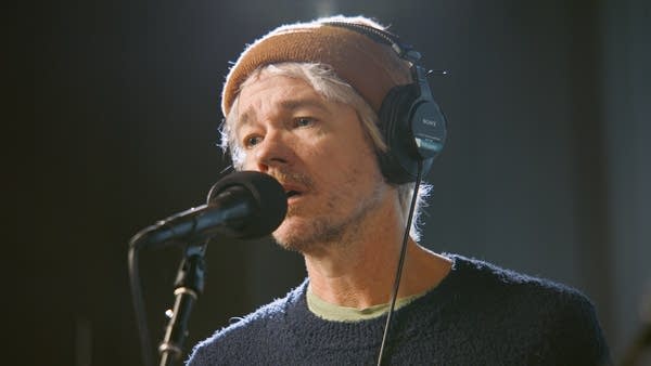 A man sings in a recording studio