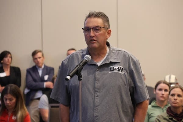 A man talks at a microphone