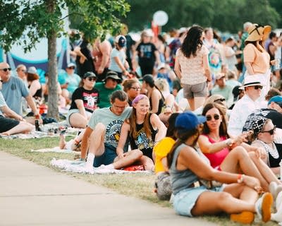 Music fans relax on the lawn at a summer music festival