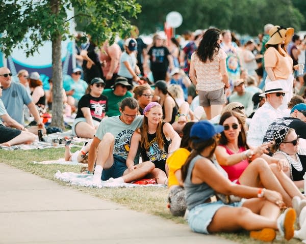 Music fans relax on the lawn at a summer music festival