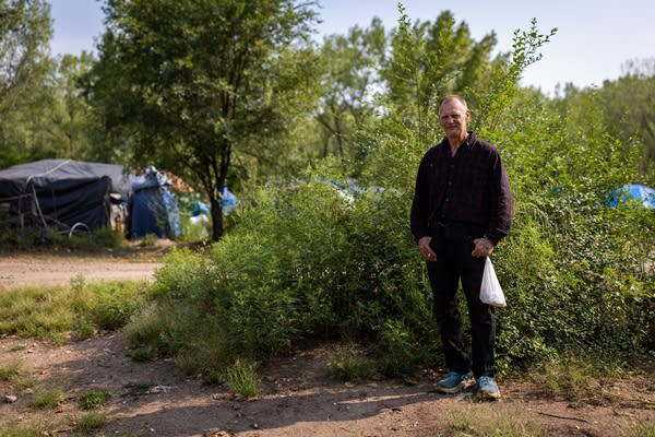 A man stands in an encampment