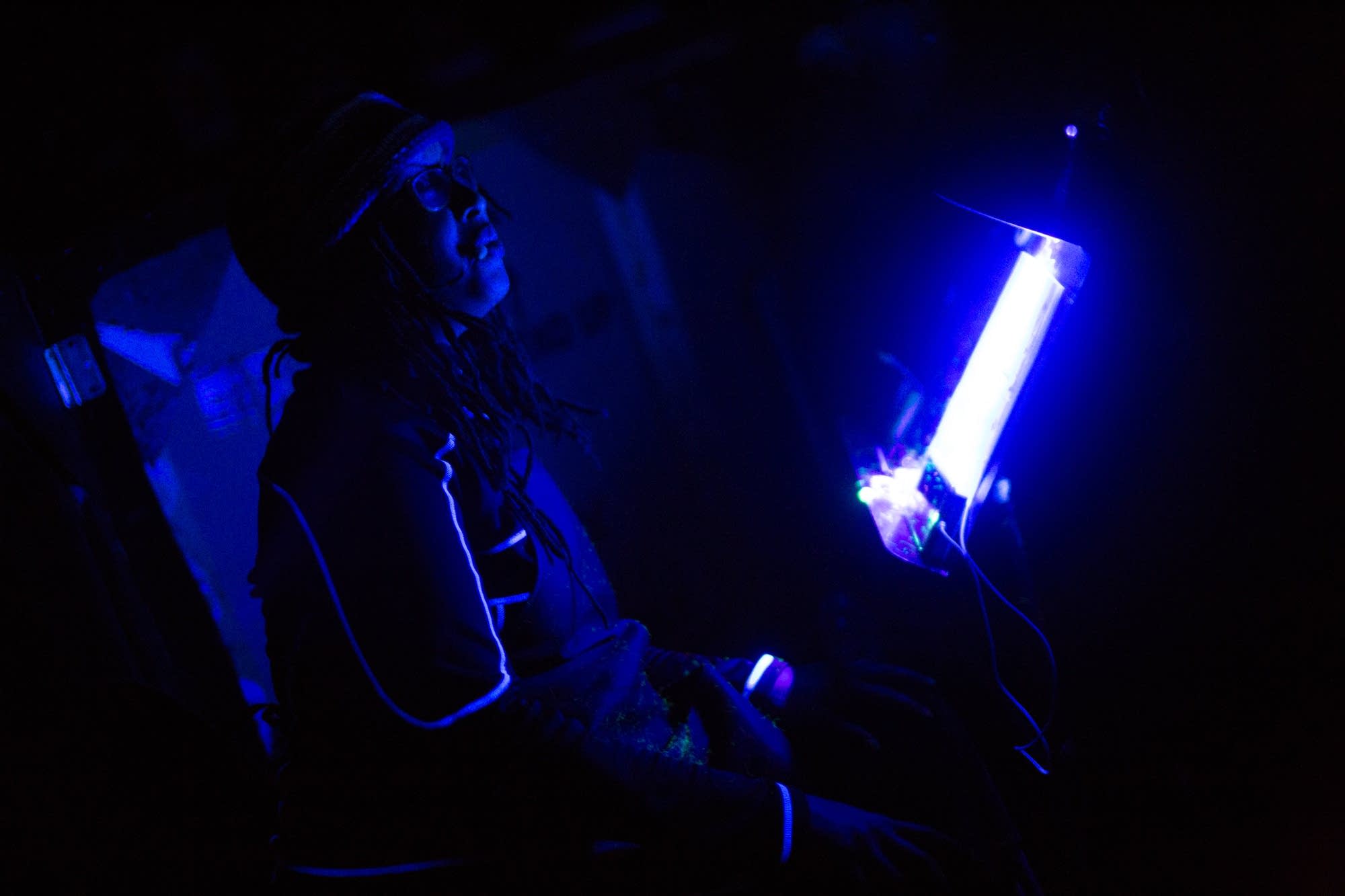 Mankwe Ndosi reads off a script lit by blacklight.