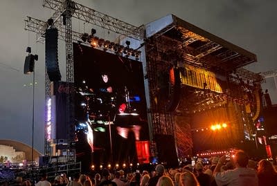 Music fans watching a performance onstage and on large screens