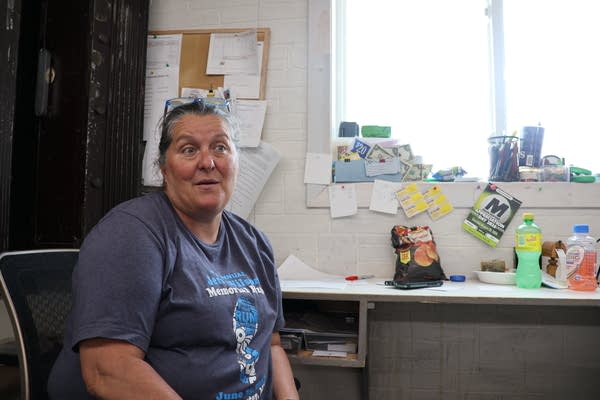 A woman posing for photo by a desk