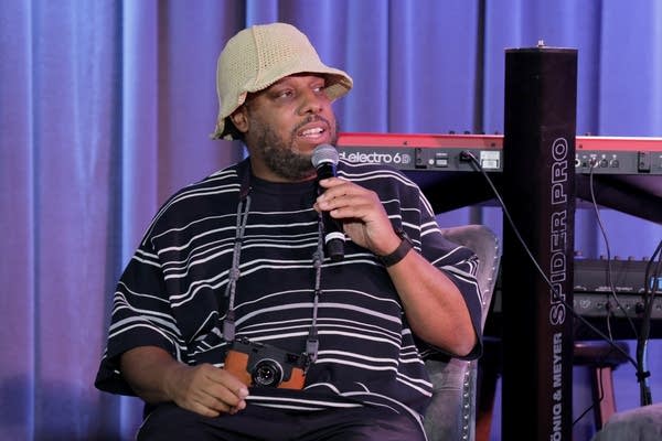 A man speaks into a microphone during a panel discussion event