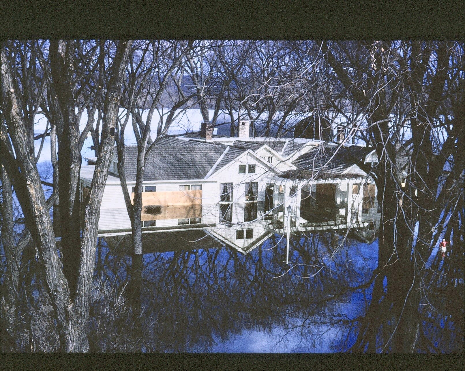 A house on the wrong side of the dike is overcome by floodwaters.