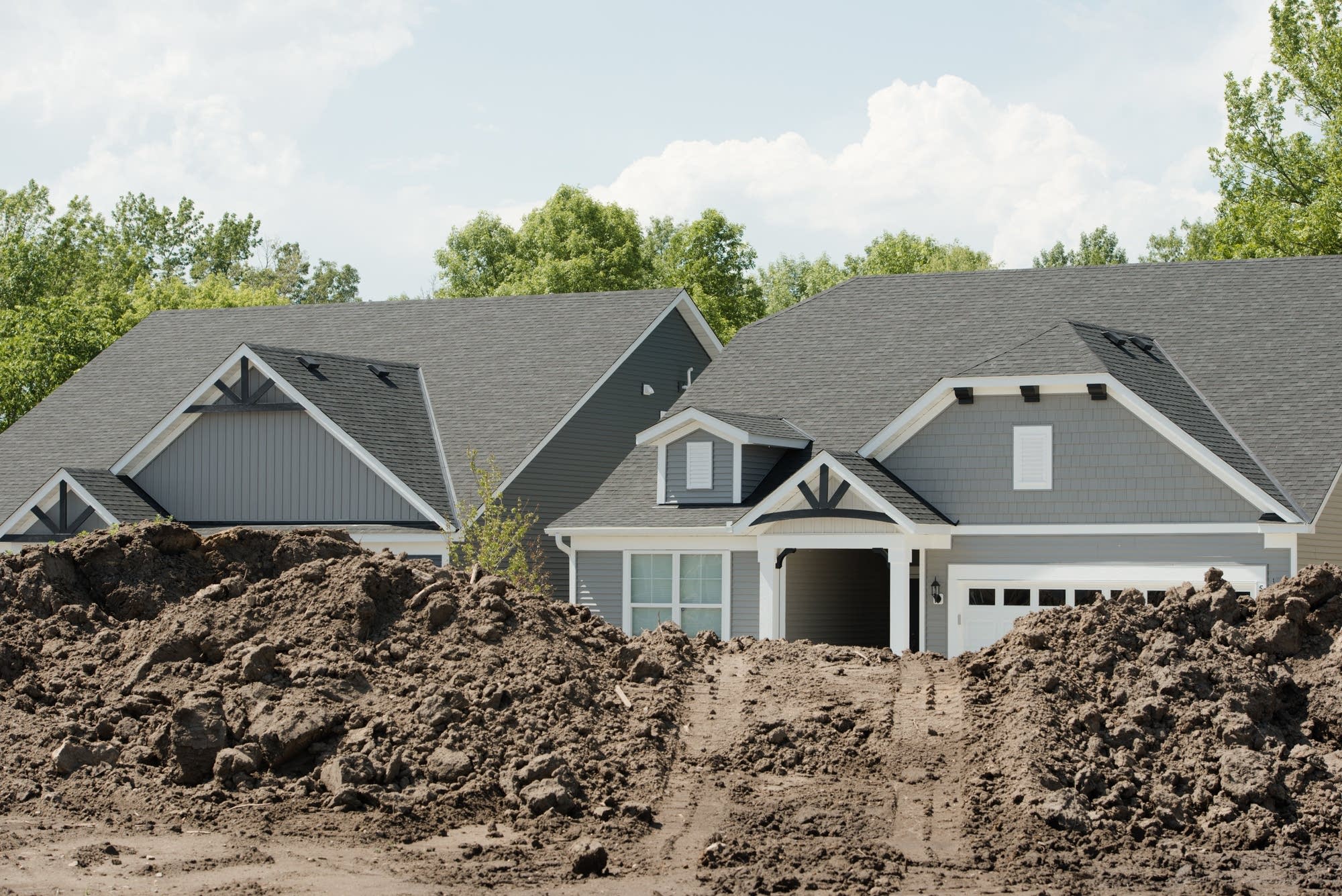 New homes peek out from behind mounds of excavated dirt.