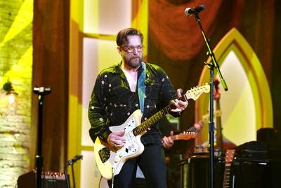 A man plays guitar onstage