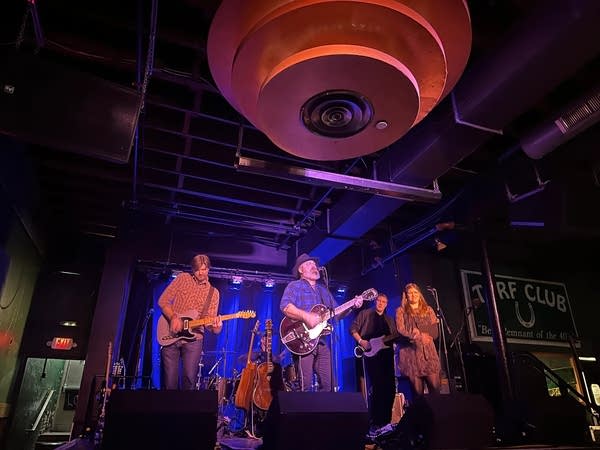 A band performing onstage in a small music venue